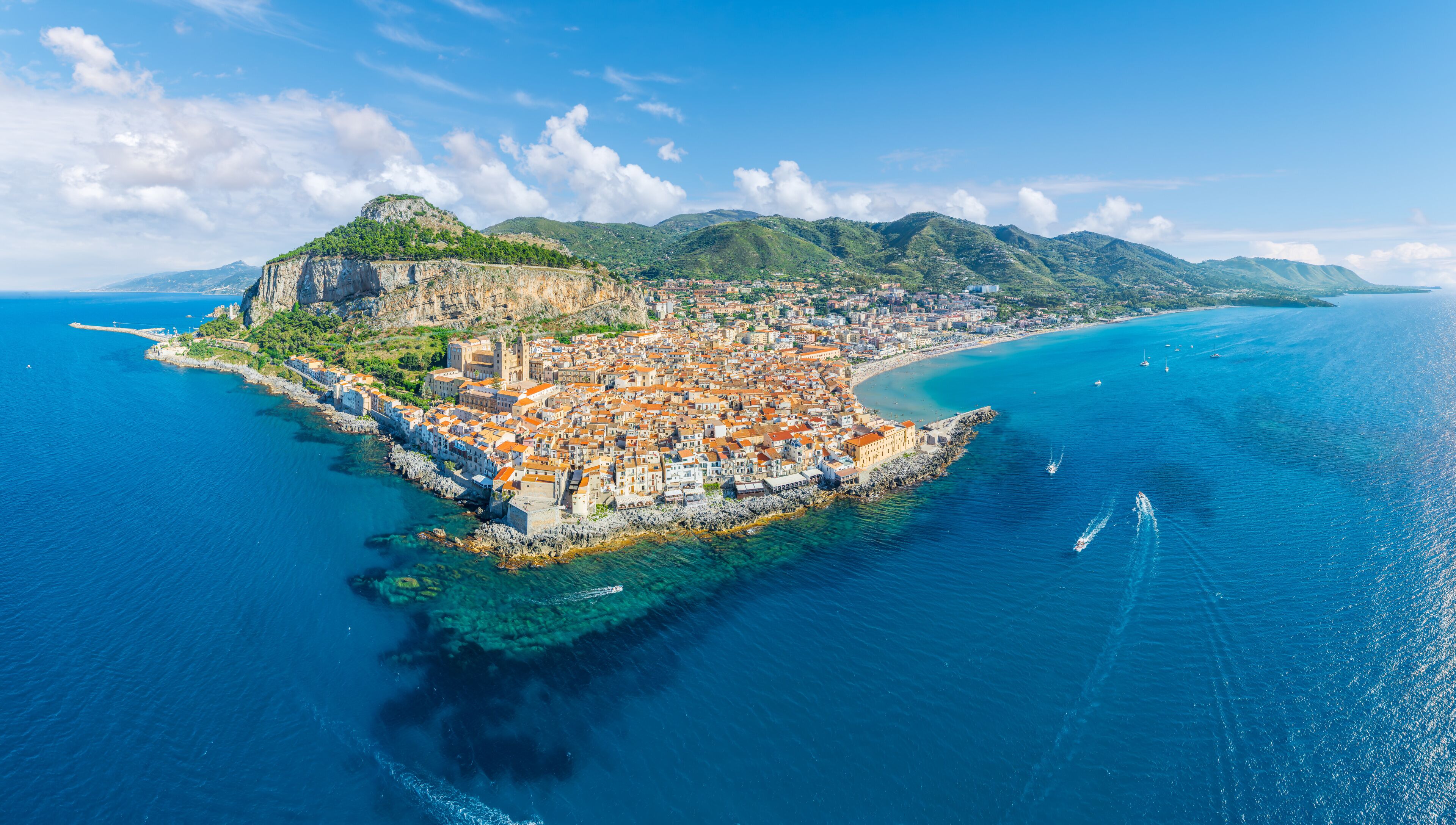 Aerial view showcasing its historic architecture, stunning coastline, and Mediterranean charm of Cefalu, Sicily.