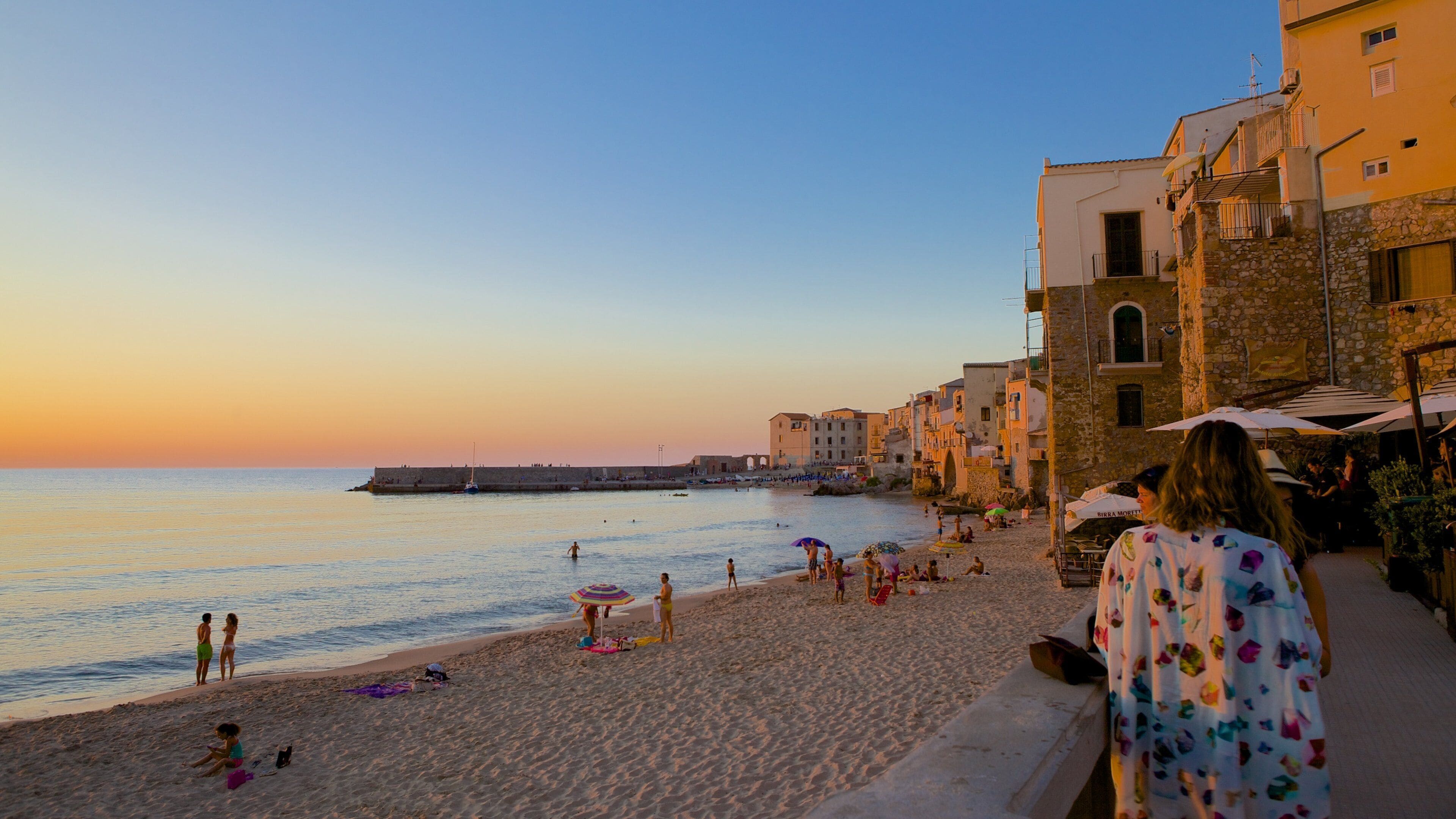 Cefalu featuring a coastal town, a sunset and a sandy beach