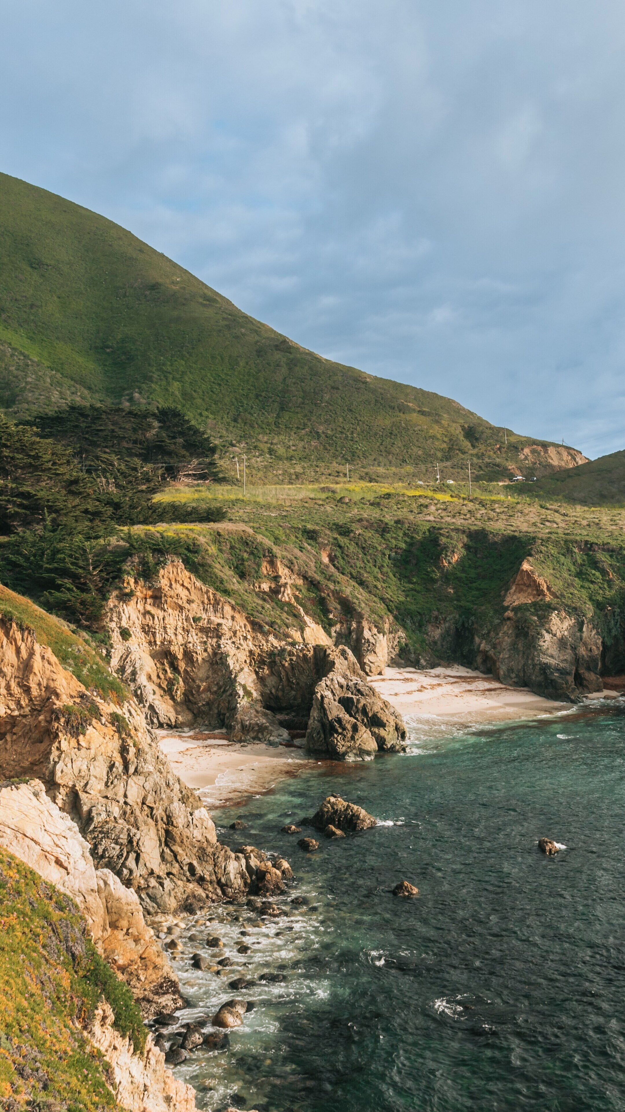 Garrapata Beach overlooks the rugged California coastline with lush greenery and rocky cliffs under a clear sky