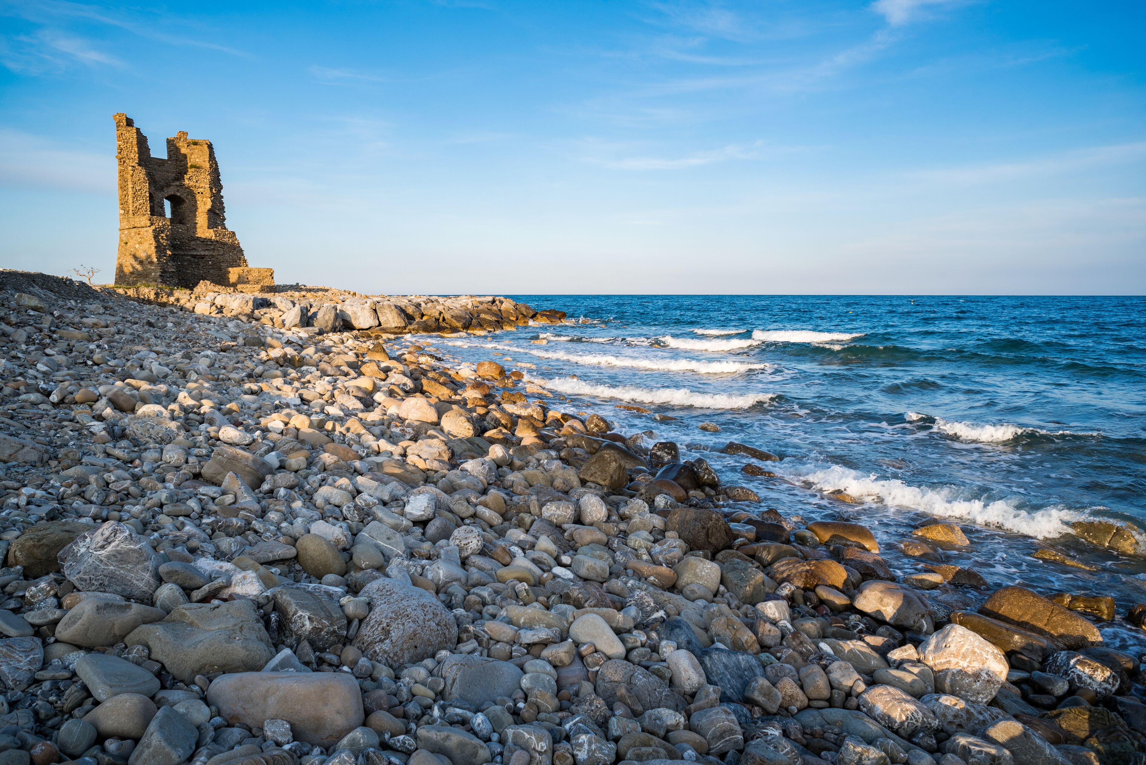 A rocky shoreline with a historic stone structure.
