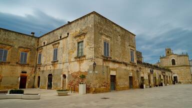 A historic building with a stone facade, multiple windows, and a bell tower.