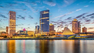 A city skyline with modern skyscrapers and a river in the foreground.
