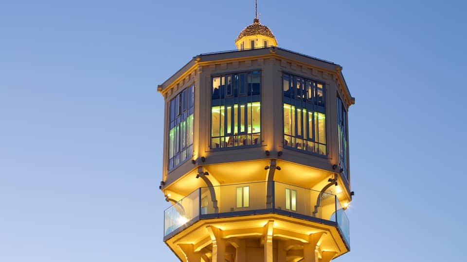 A tower with illuminated windows and a spire.