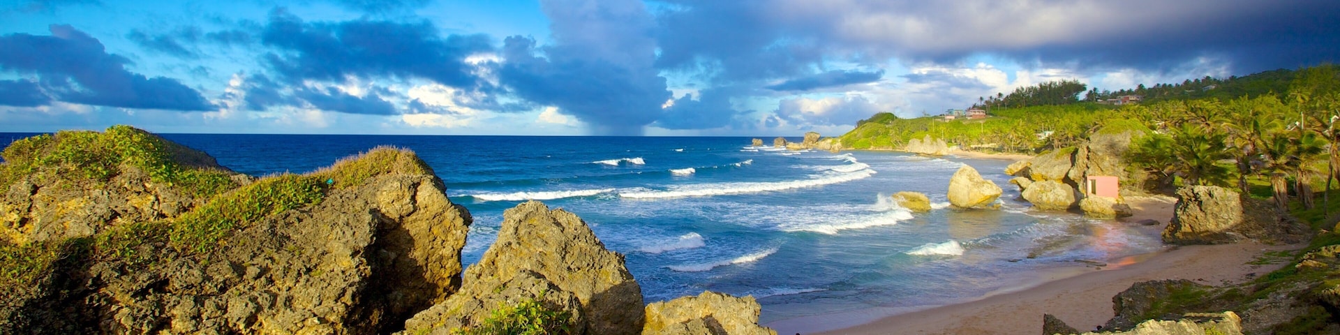 A coastal landscape with rocky cliffs, a sandy beach, and the ocean.