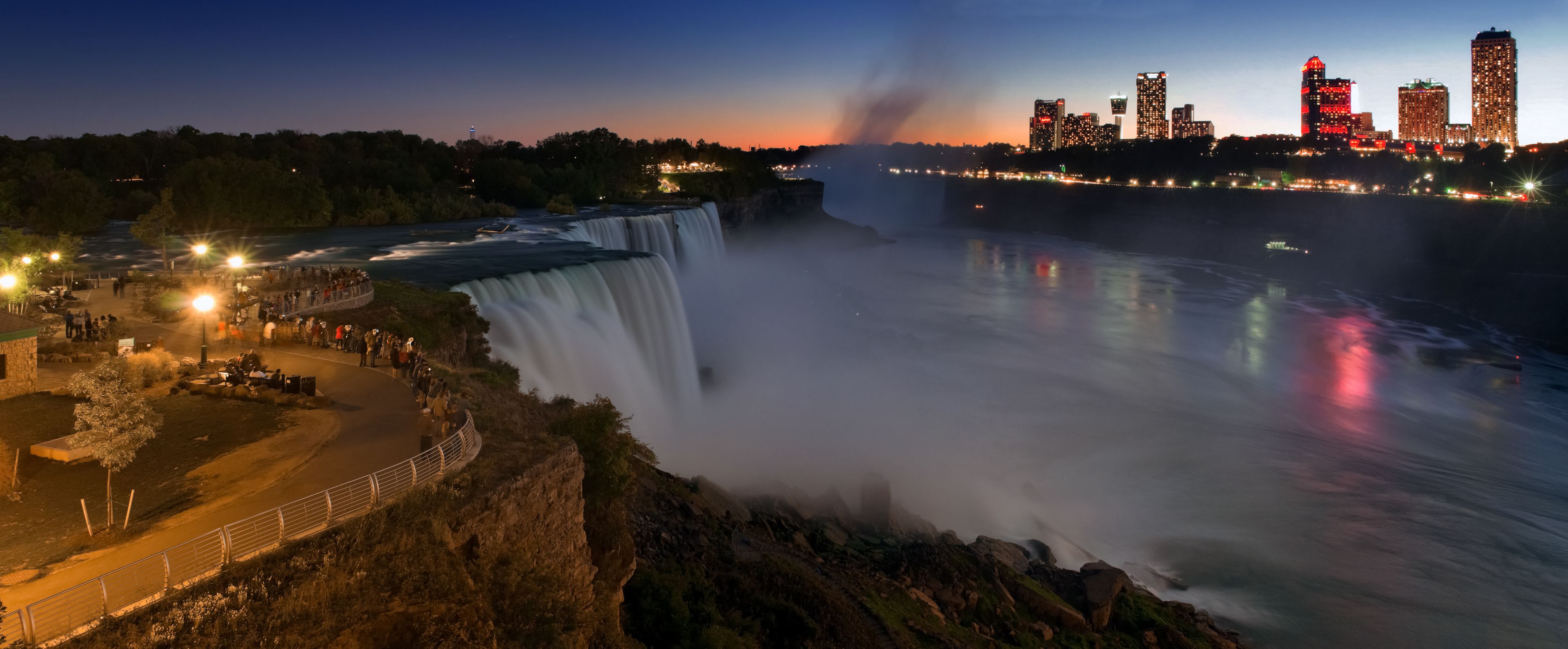 A waterfall with a city skyline in the background.