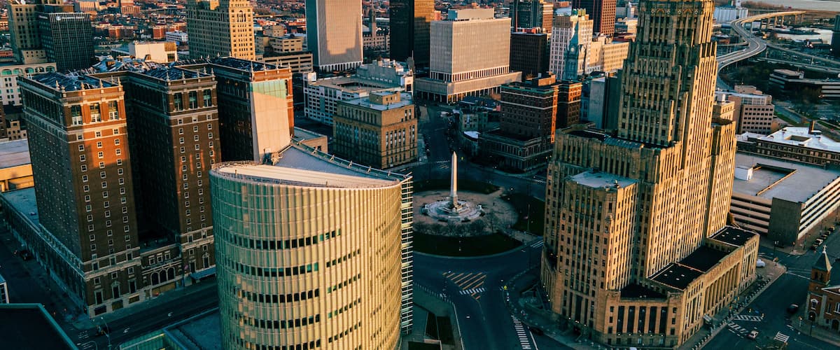 A cityscape with a variety of skyscrapers, including a tall, pointed building and a cylindrical structure.
