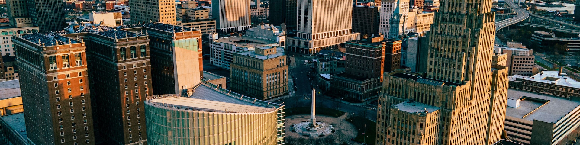 A cityscape with a variety of skyscrapers, including a tall, pointed building and a cylindrical structure.