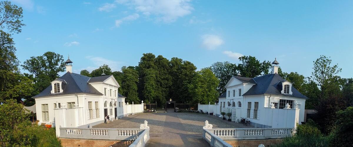 A symmetrical building complex with a central pathway leading to a gated entrance.