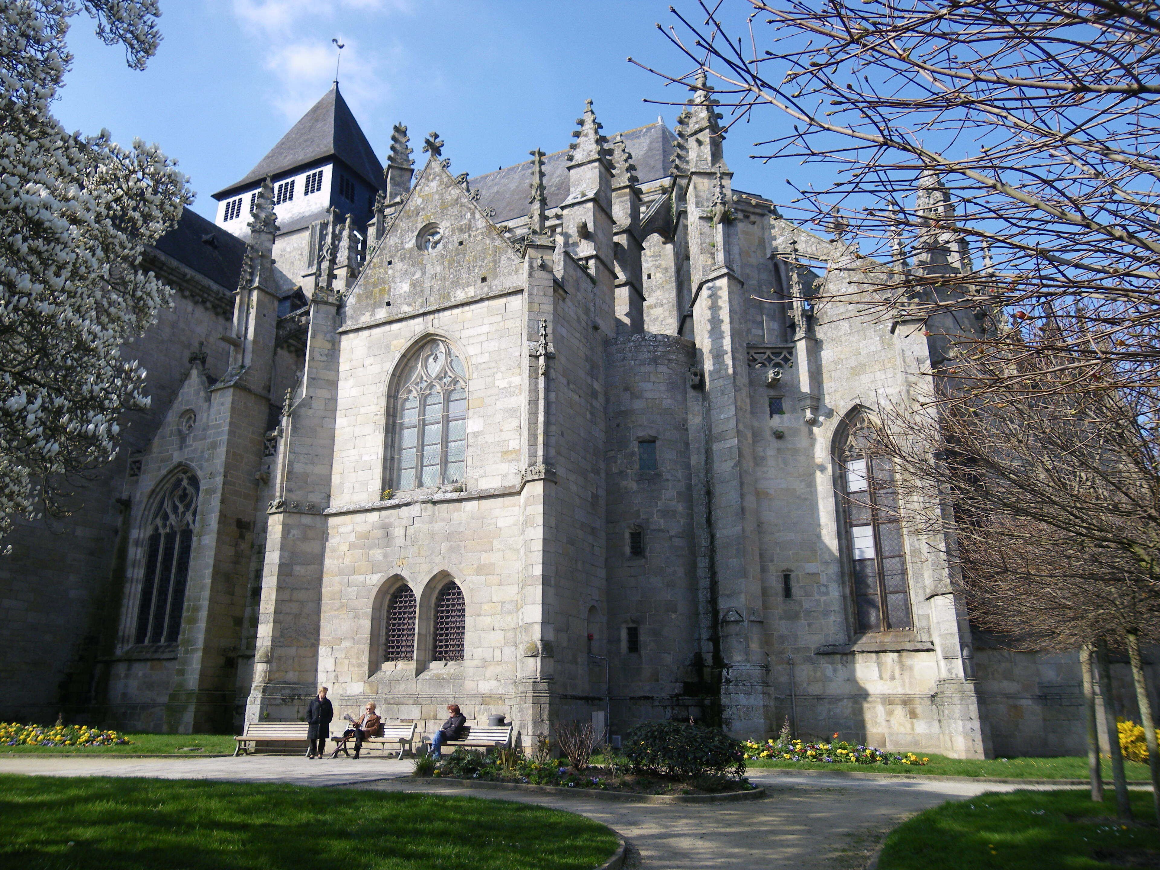 A historic stone building with intricate architecture, including pointed arches and a tower.