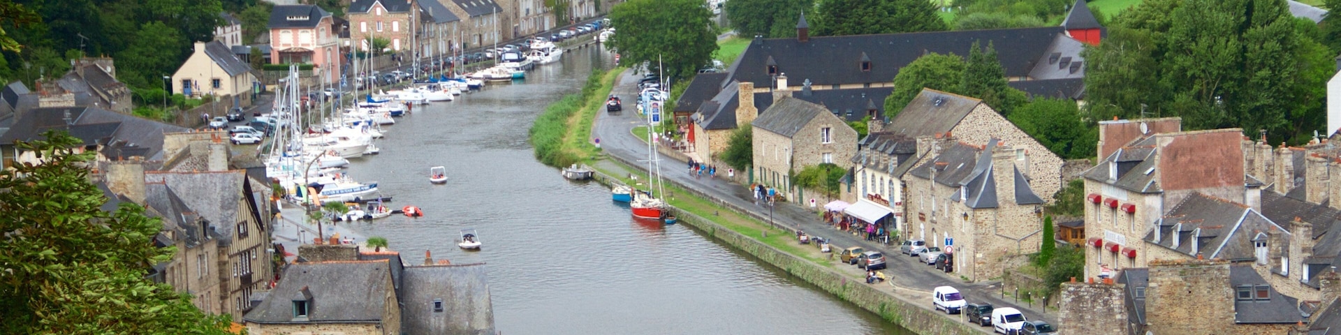 A riverside town with a stone bridge, boats, and historic buildings.