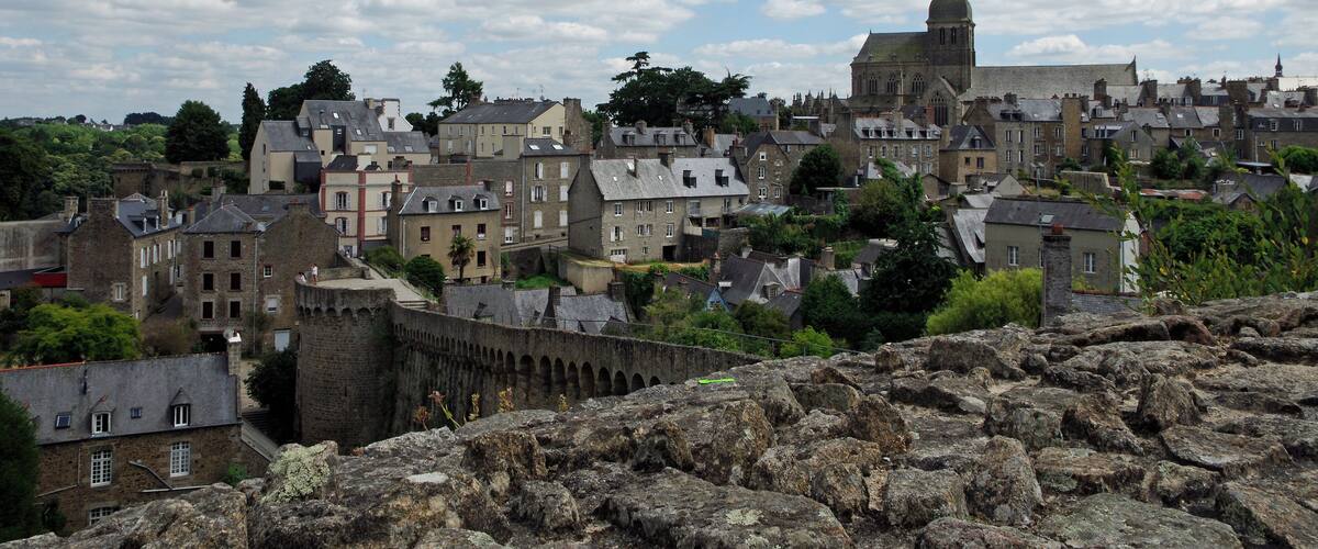 Un pueblo histórico con una iglesia destacada y ruinas de un castillo.