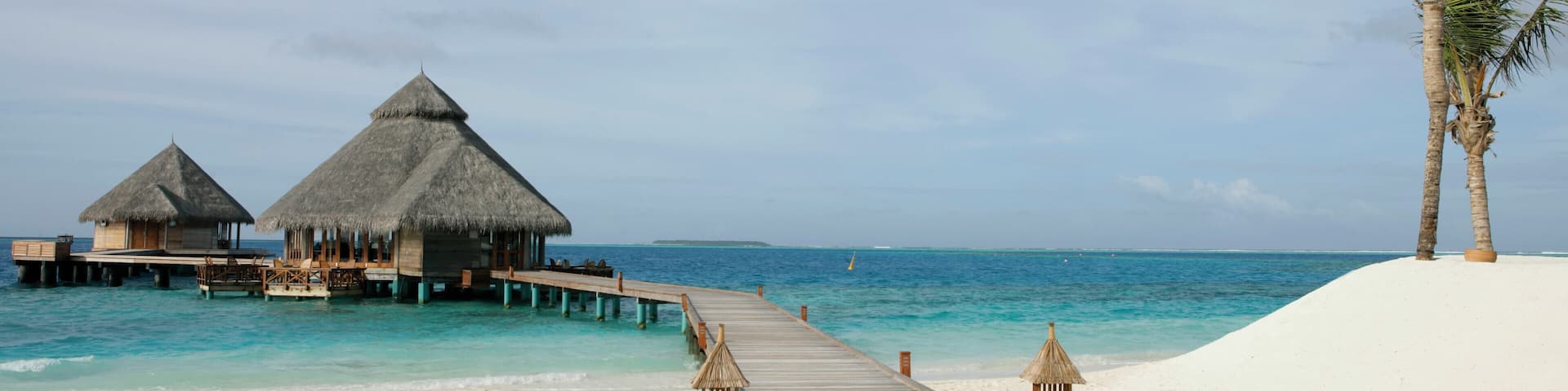 Boardwalk guiding to two bungalows in the ocean