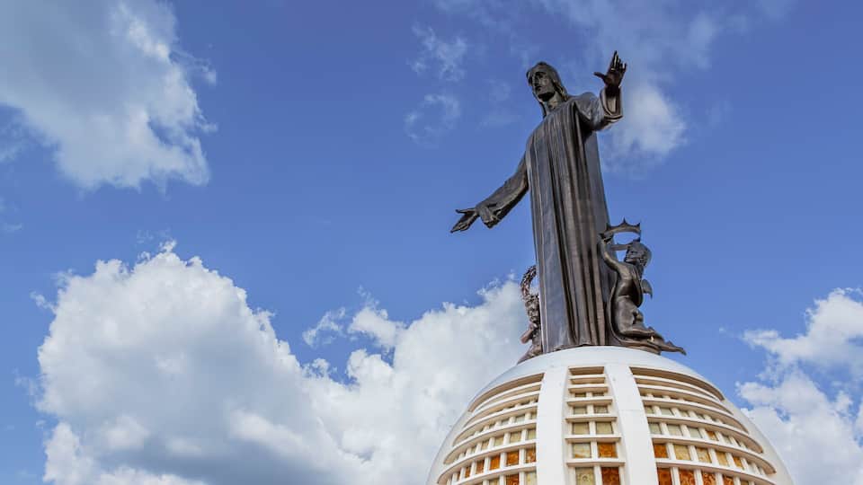 A statue on a building with a clear blue sky in the background.