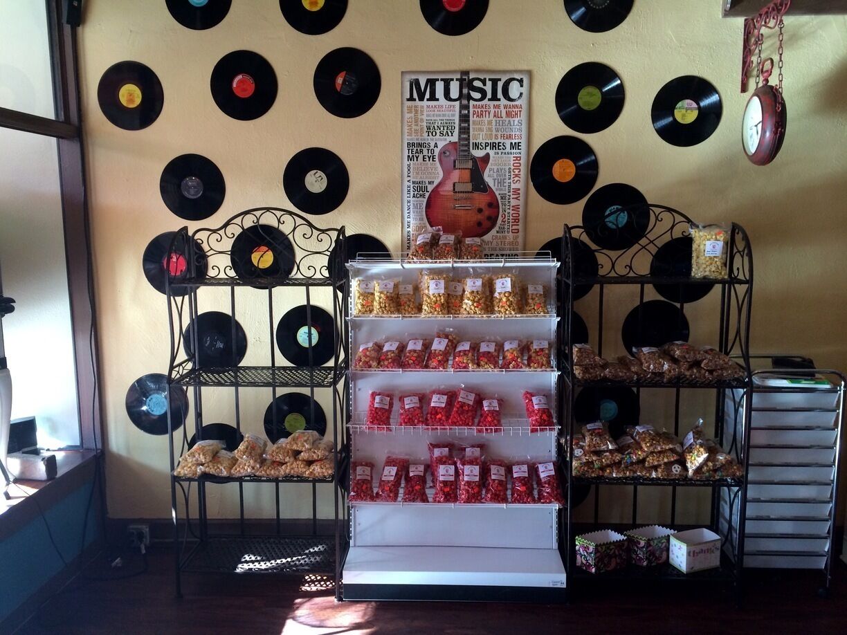 Gourmet popcorn shop with bags of freshly made popcorn mixes and other treats for sale.