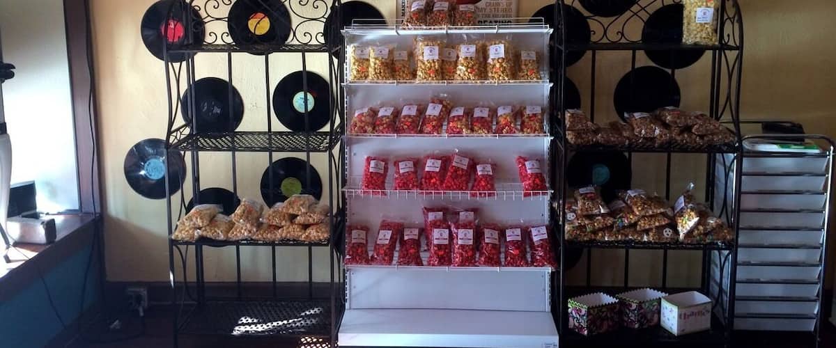 Gourmet popcorn shop with bags of freshly made popcorn mixes and other treats for sale.