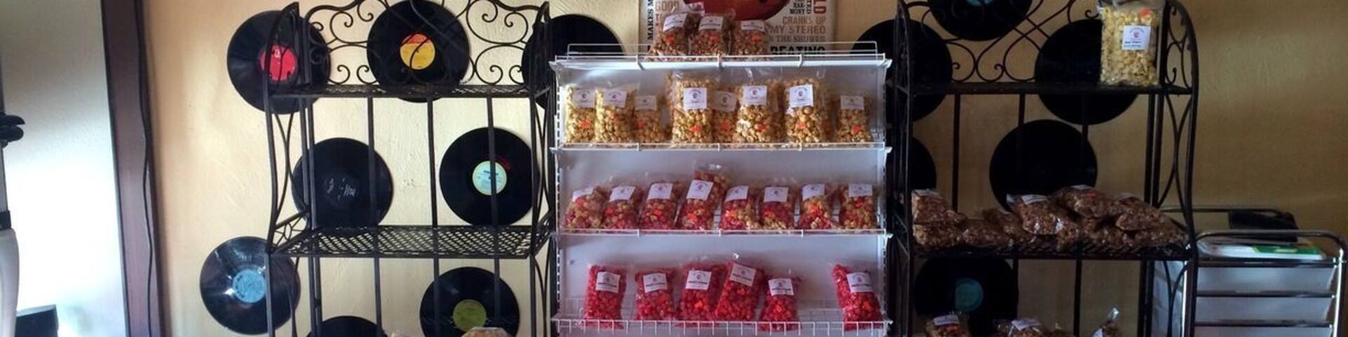 Gourmet popcorn shop with bags of freshly made popcorn mixes and other treats for sale.