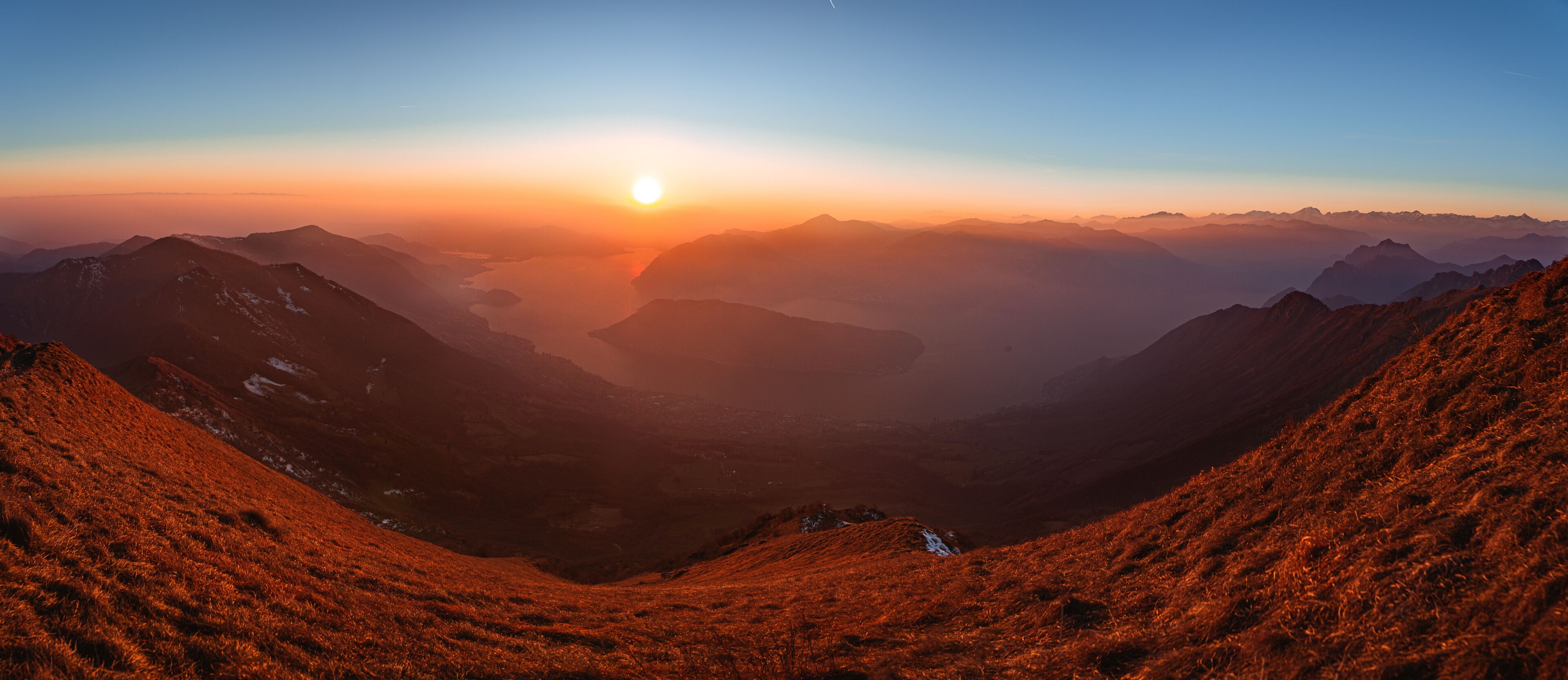 The Lombard pre-Alps near Lake Iseo, seen at sunset from one of the most beautiful viewpoints in the Province of Brescia: Punta Almana, near the town of Sale Marasino, Italy - February 2023.