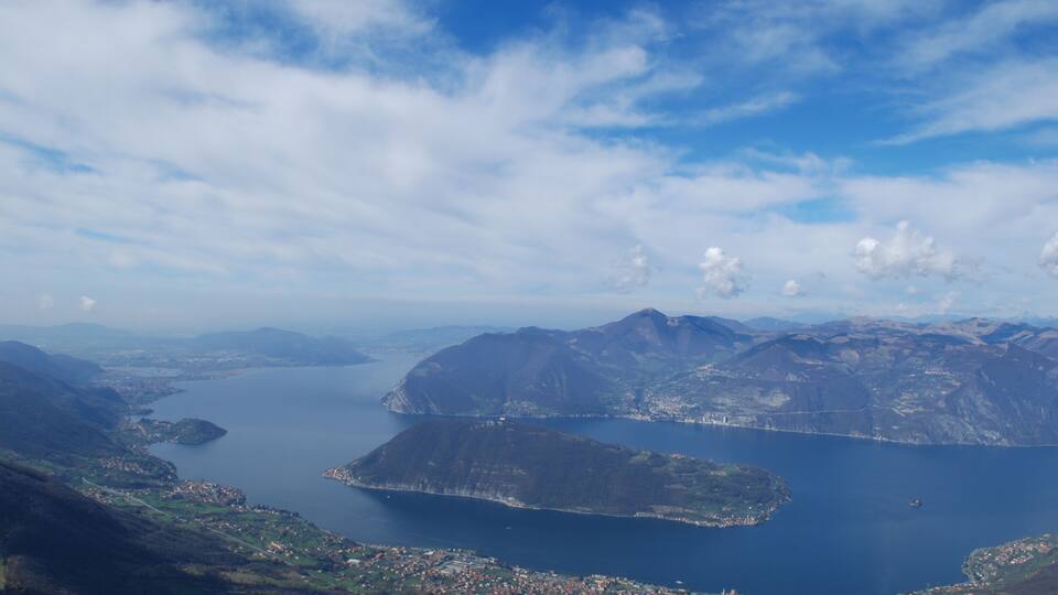 A mountainous landscape with a large lake and a town in the foreground.