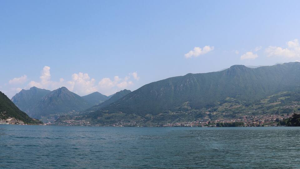 A lake with mountains in the background and a town on the opposite shore.