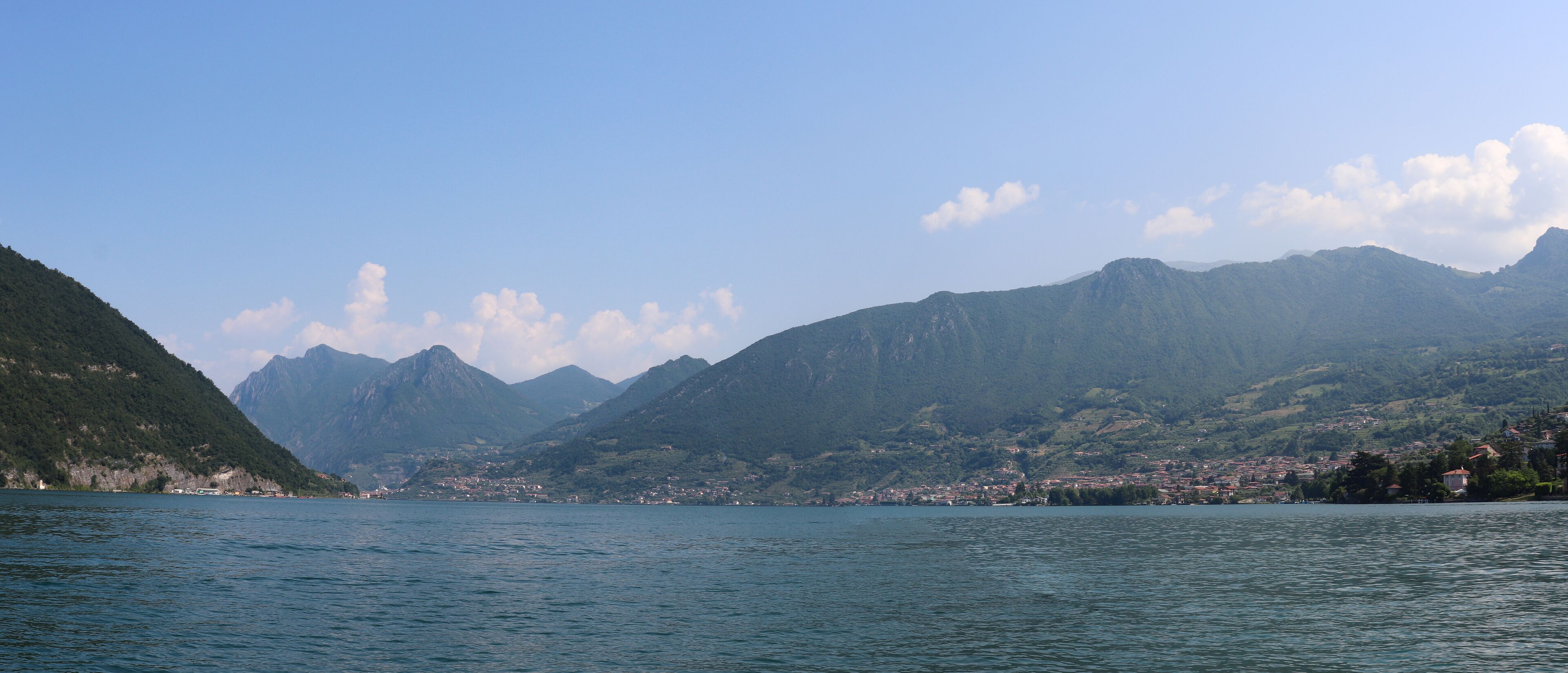 A lake with mountains in the background and a town on the opposite shore.