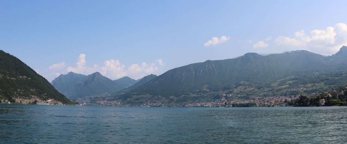 A lake with mountains in the background and a town on the opposite shore.