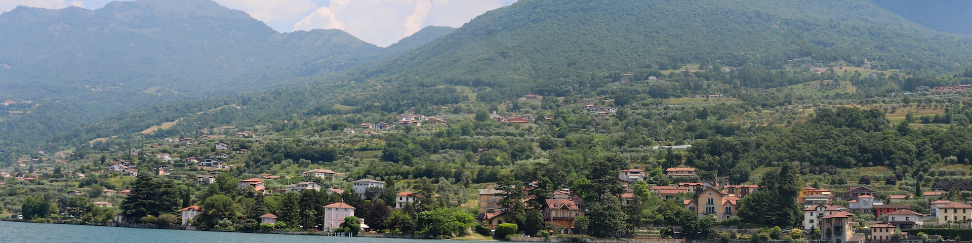 Un lago con un pueblo en la orilla, rodeado de montañas.