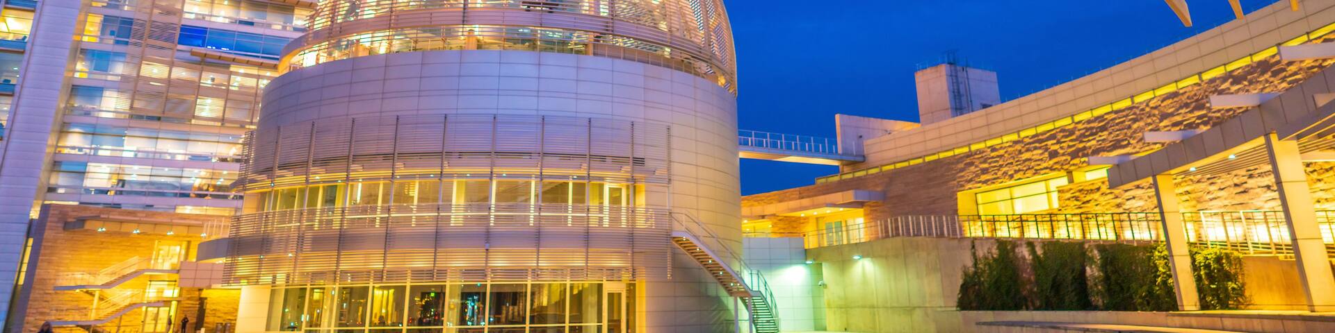 A modern building with a large dome and a glass facade.