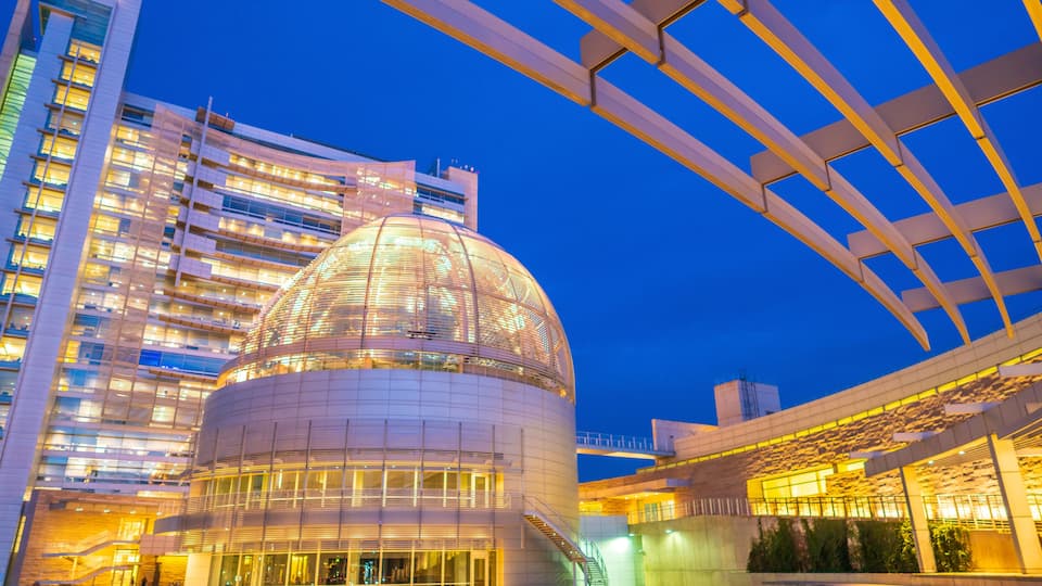 A modern building with a large dome and a glass facade.