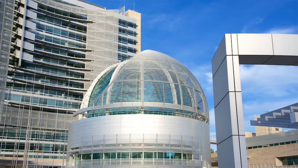 A modern architectural structure with a curved glass dome and a grid-like facade.