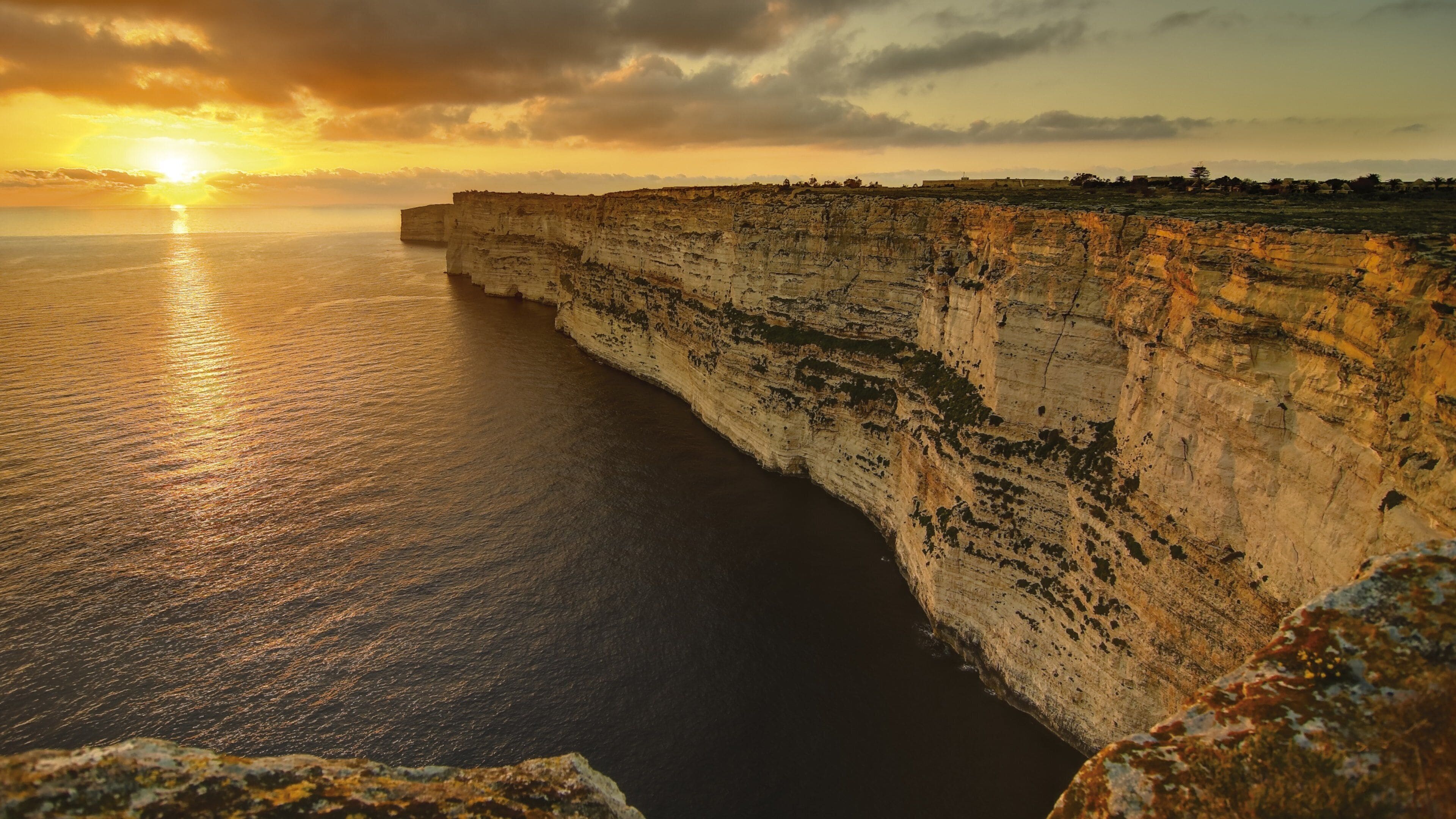 Gozo showing rugged coastline, a sunset and landscape views