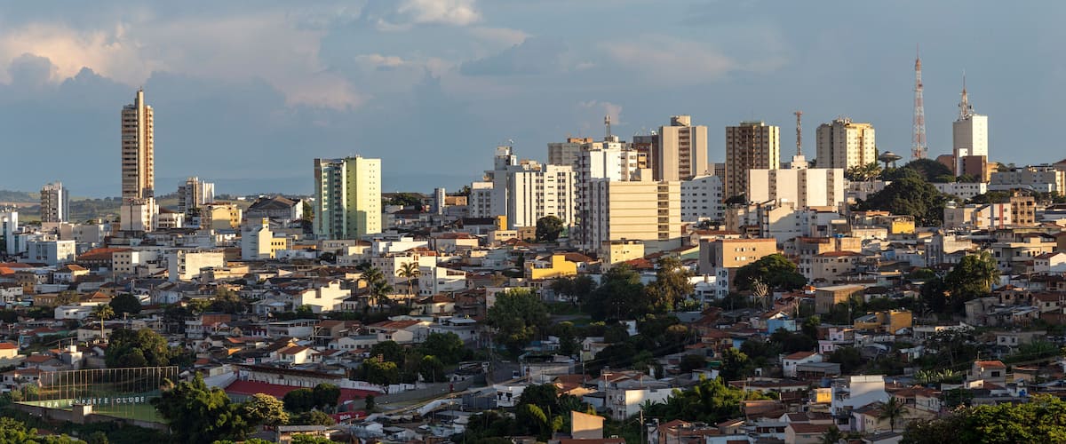 A densely packed urban skyline with a mix of high-rise and mid-rise buildings, a prominent tower, and a stadium in the foreground.