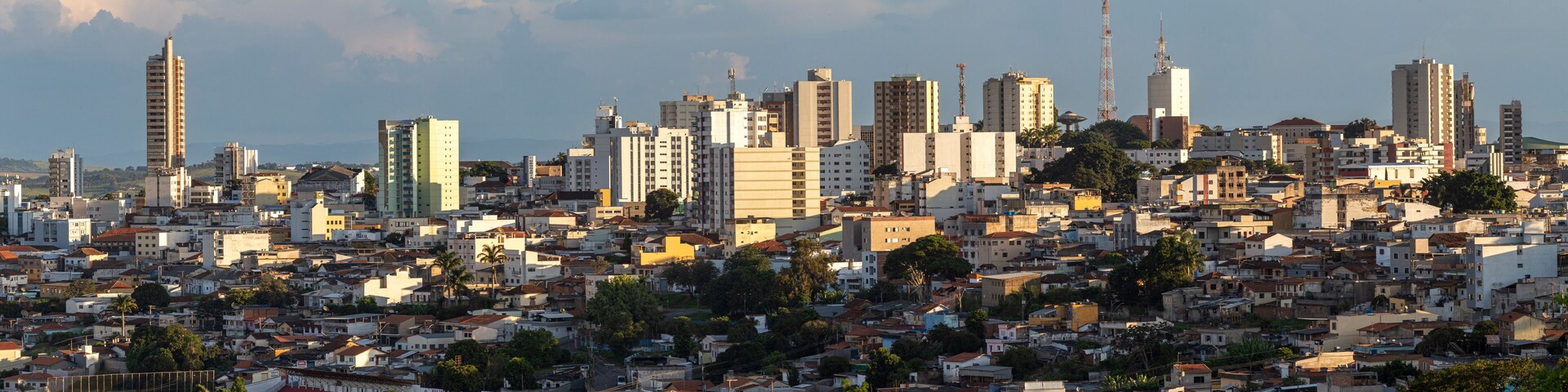 A densely packed urban skyline with a mix of high-rise and mid-rise buildings, a prominent tower, and a stadium in the foreground.