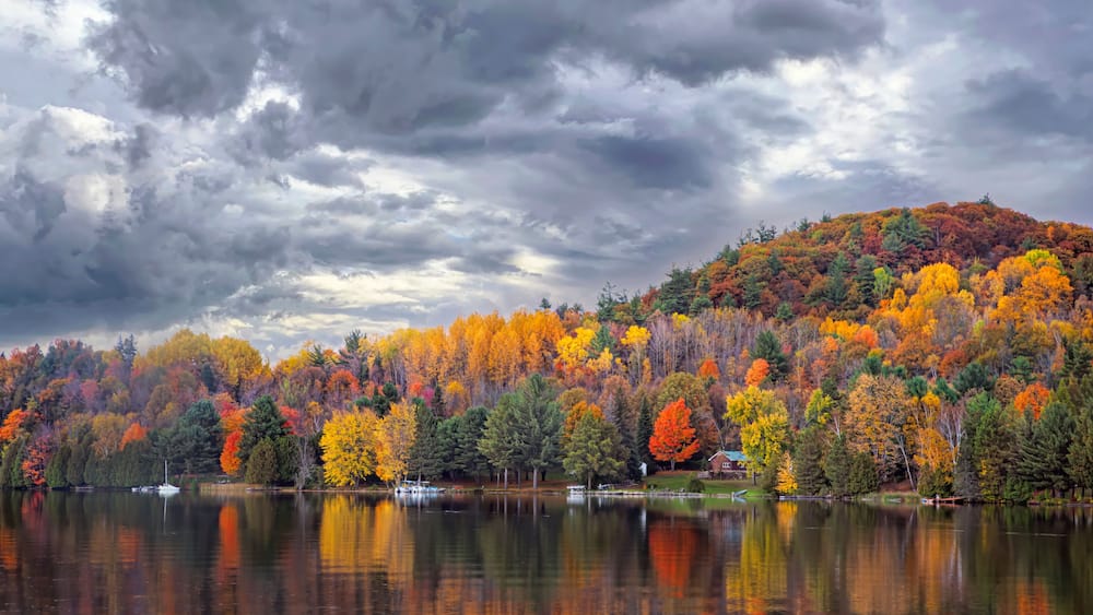 Fall colours along the Gatineau river reflected in water, Quebec, Canada