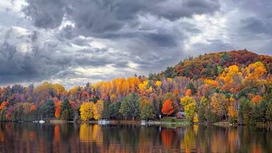 Fall colours along the Gatineau river reflected in water, Quebec, Canada