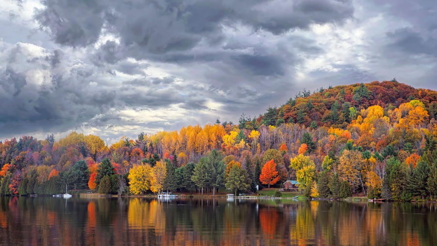 Fall colours along the Gatineau river reflected in water, Quebec, Canada