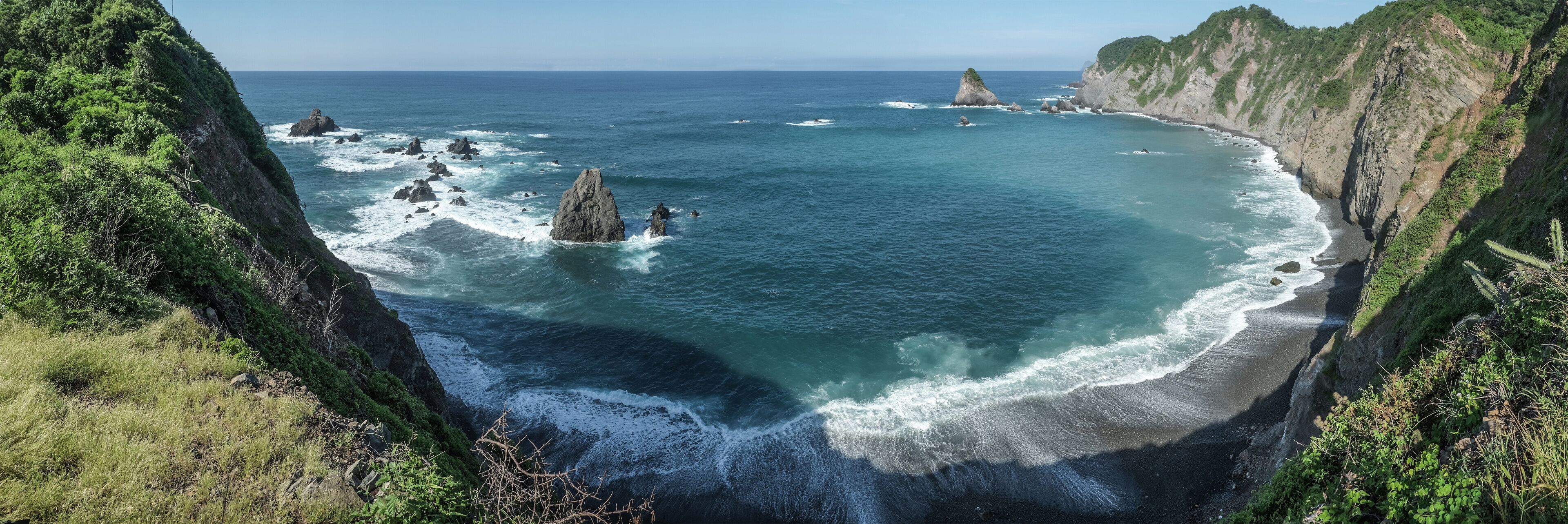 A coastal landscape with rocky outcrops and cliffs.