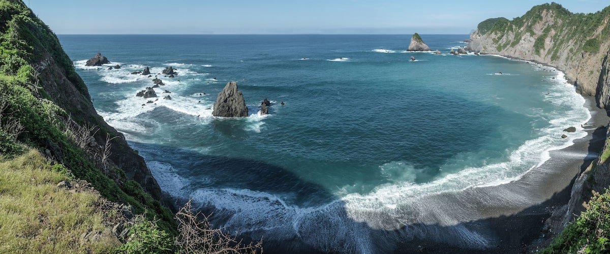 A coastal landscape with rocky outcrops and cliffs.