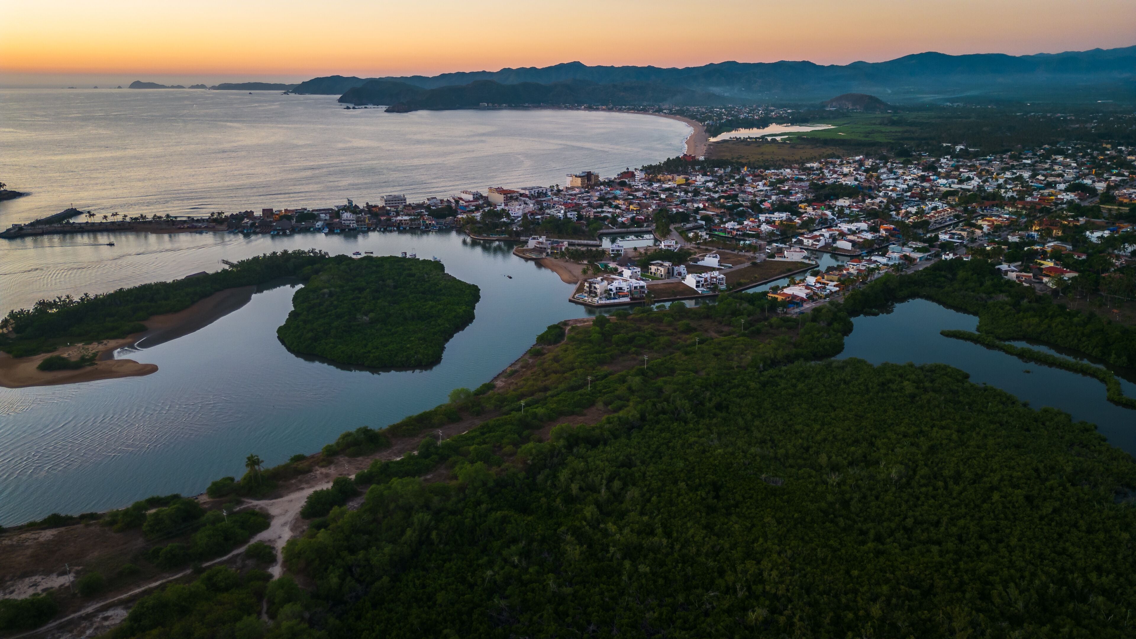 Barra de Navidad Aerial of Jalisco Mexico resort beach town with pacific coastline ocean view at sunset and lake lagoon