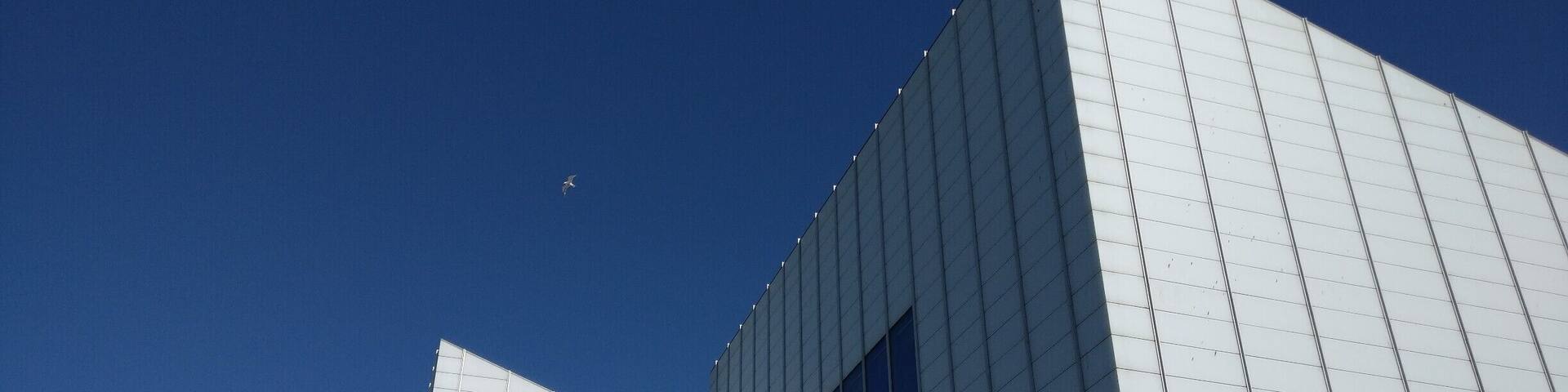 A modern architectural structure with a grid-like facade and sharp angles.