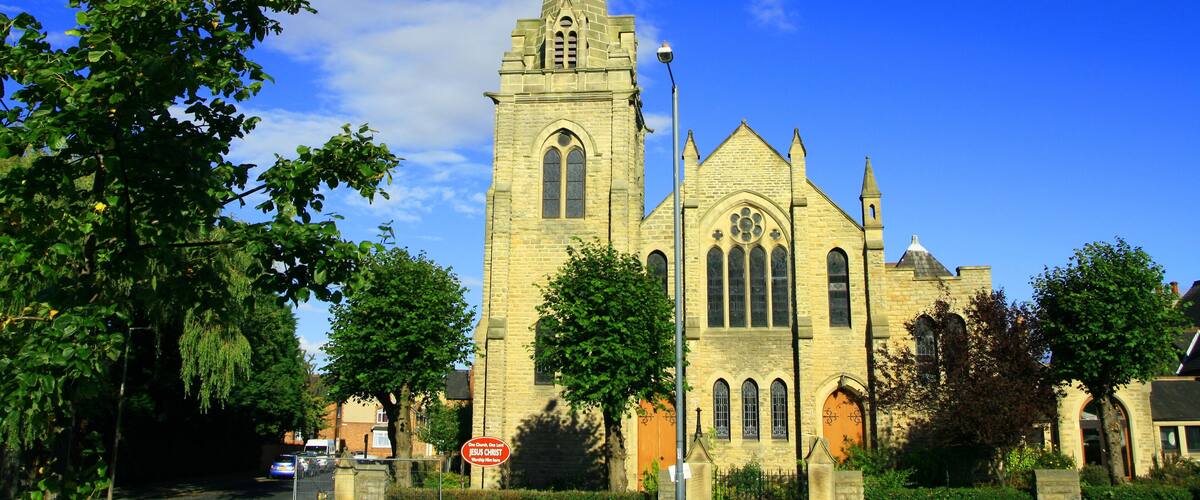 A historic church with a tall spire and arched windows.