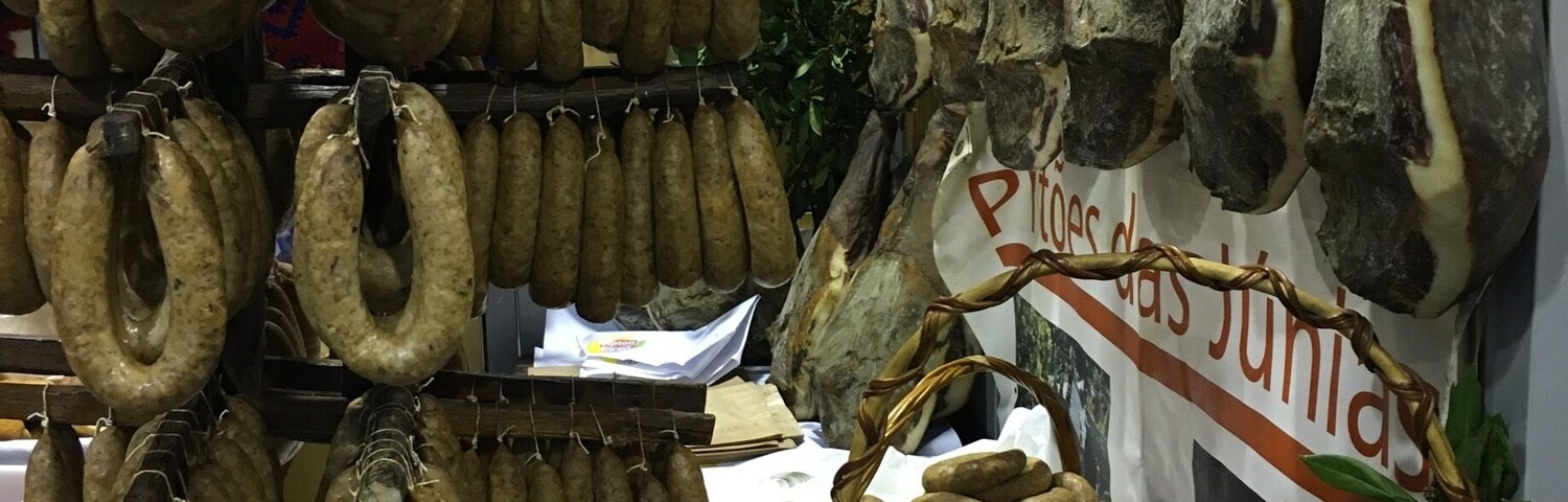 Variedad de embutidos secos exhibidos en un puesto de mercado.