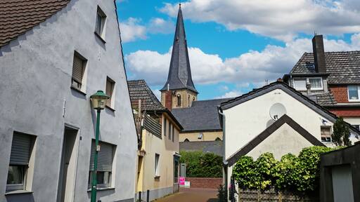 Grefrath (NRW), Germany - May 1. 2024: Street with old houses in the direction of the church (focus on center)