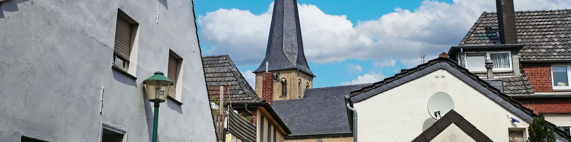 Grefrath (NRW), Germany - May 1. 2024: Street with old houses in the direction of the church (focus on center)