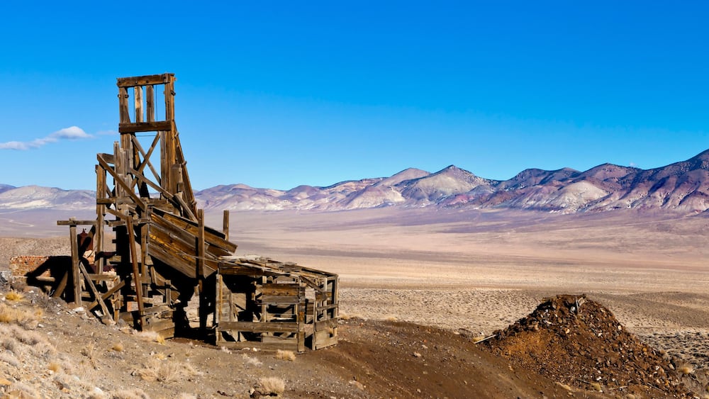 Old wooden mining hopper bin under blue sky in the Nevada Desert near a ghost town.