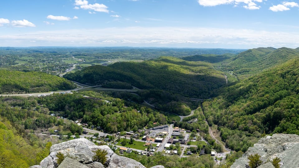 A valley with a small town surrounded by mountains and a river.