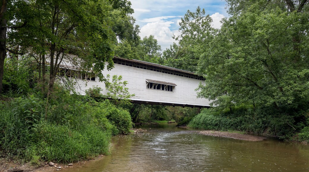 Built in 1856, the historic white Portland Mills Covered Bridge now crosses Little Raccoon Creek in Parke County, Indiana.