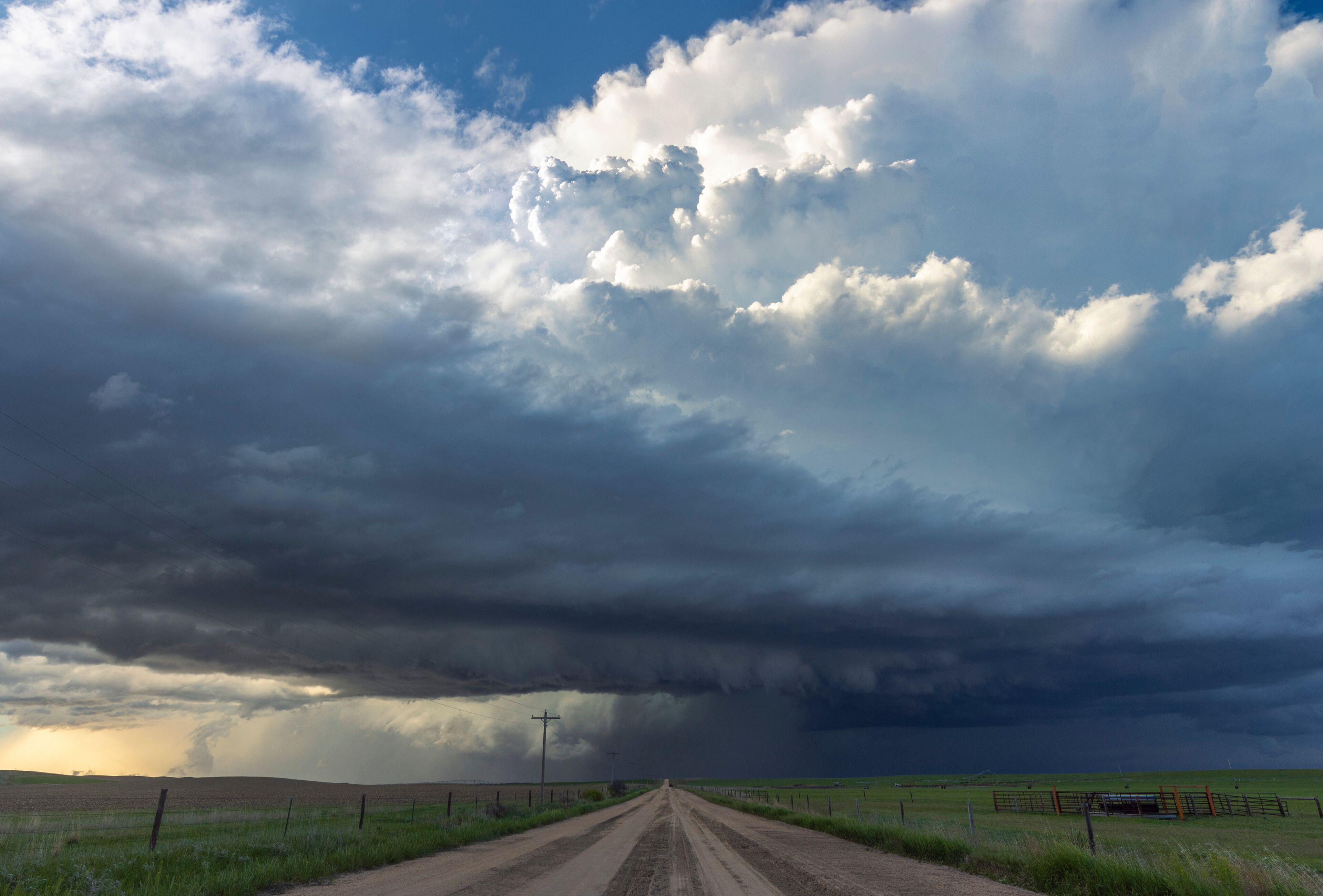 An enormous supercell thunderstorm crosses a dirt road in rural Nebraska; Imperial, Nebraska, United States of America