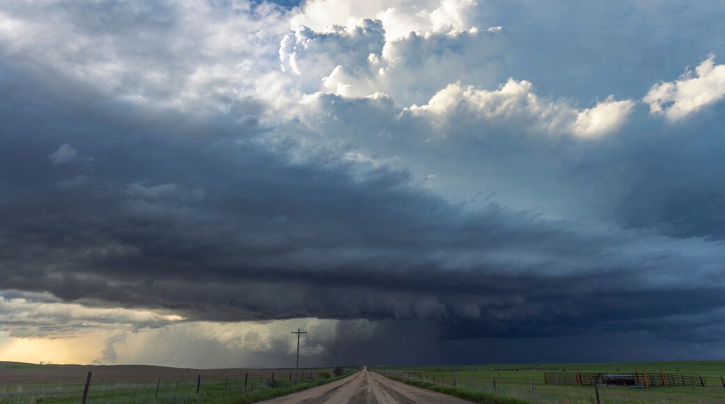 An enormous supercell thunderstorm crosses a dirt road in rural Nebraska; Imperial, Nebraska, United States of America