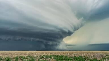 Une tornade qui touche le sol dans un champ.