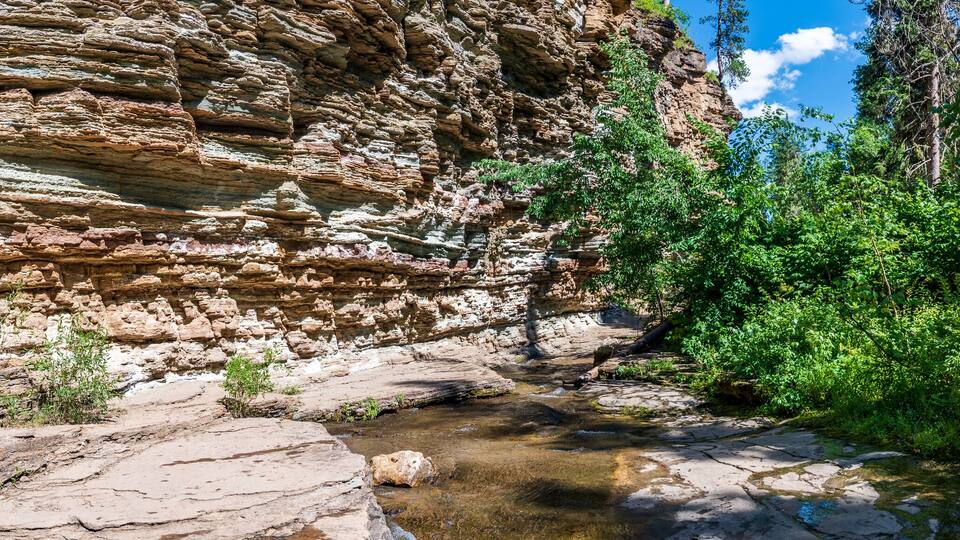 A rocky canyon with a stream flowing through it.